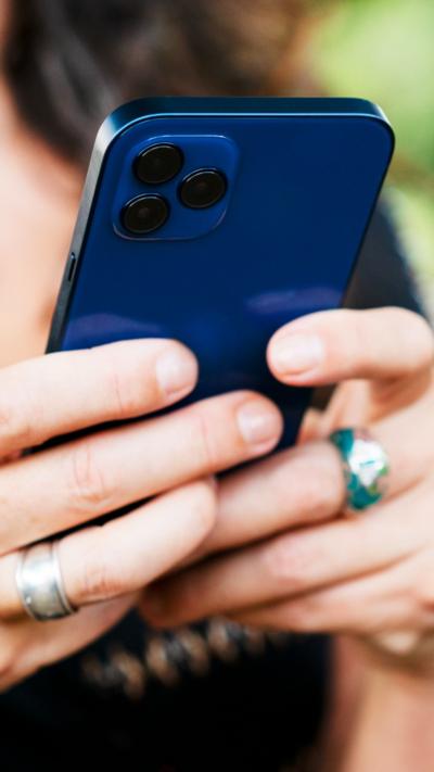 Woman's hands hold blue iPhone. 
