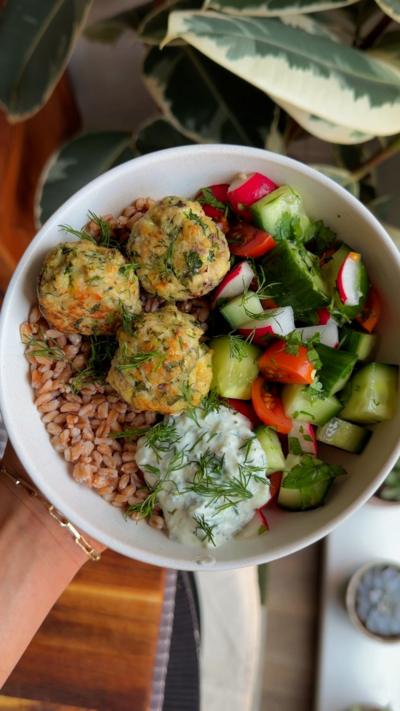 A white bowl containing meatballs, vegetables and rice