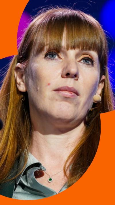 Angela Rayner has long ginger hair and wears a green suit