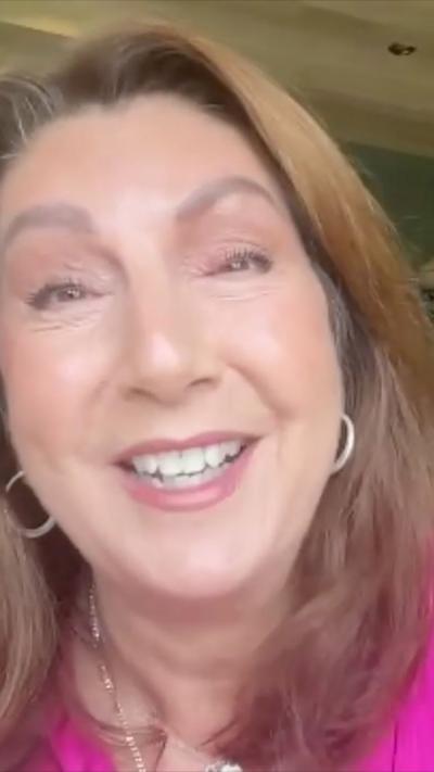 Smiling woman with long brown hair and hoop earings