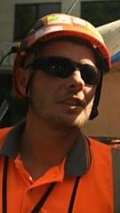 A younger man in an orange hard hat