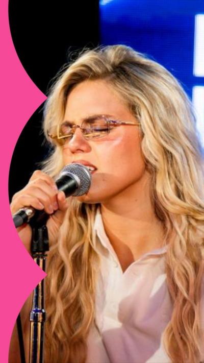 Artist Reneé Rapp signing into a mic with the Radio 1 Live Lounge logo in the background