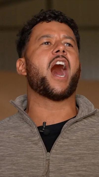 Man stands with mouth open while in song