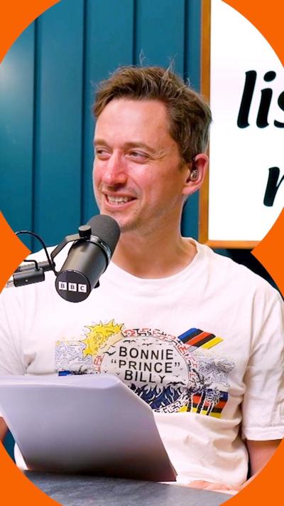 John Robins in the podcast studio, sat at table in front of a microphone.