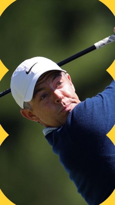 Rory McIlroy wears a white cap and is turned after taking a shot. 