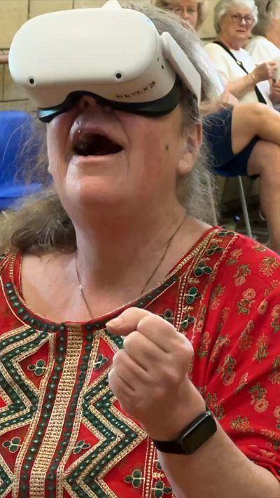 Woman smiling using a VR headset.