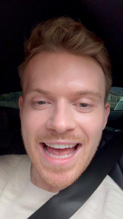 Max Baledge talks to the camera while sitting in a car wearing a seatbelt