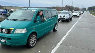 Mick Antoniw MS leaning out of a green/blue VW transported with his thumb up