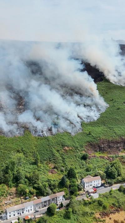 mountain greenery with thick smoke in background.