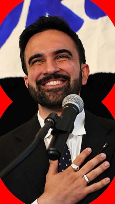 New York mayoral candidate, State Rep. Zohran Mamdani in front of a mic with hand on his heart.