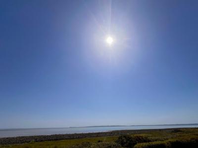 Sunny blue sky over a calm rocky coastline in Craignarget, Dumfries and Galloway