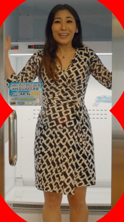 Woman standing inside a metal box with glass door