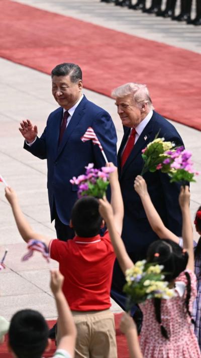 Trump and Xi walk past waving children