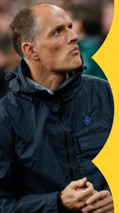 England men's football manager Thomas Tuchel wearing a black coat and looking up into the stands at Wembley
