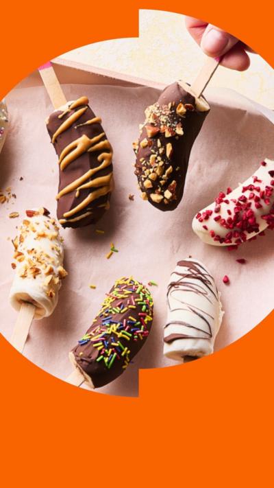 Six frozen banana lollies covered in chocolate or yogurt and various sprinklings