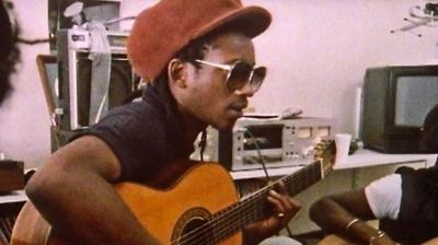 Brinsley Forde of the band Aswad playing an acoustic guitar. 