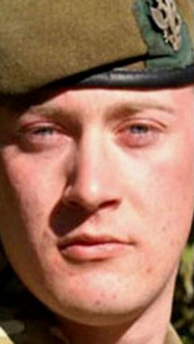 A photo of a soldier's face with a green/brown beret