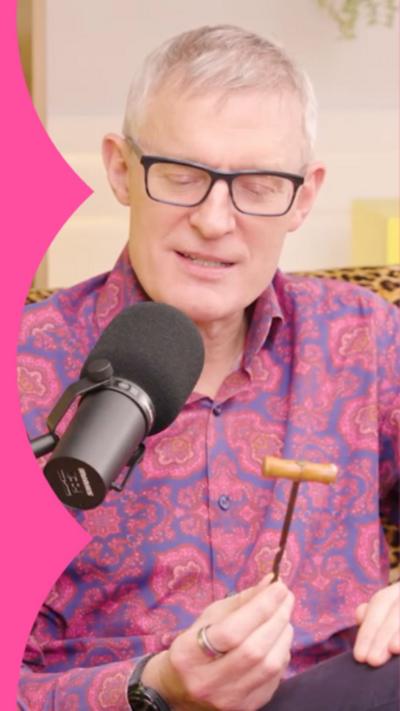 Jeremy Vine holding a gimlet tool. He's wearing a red and blue shirt and black framed glasses.