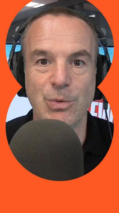 Martin Lewis looking to camera, with a microphone in front and wearing headphones.