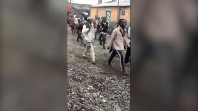 People reported to be escaped prisoners walk along the street in Goma. 