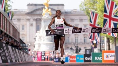 Tigst Assefa crosses the finish line to win the women's elite race during the London Marathon.