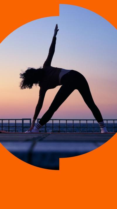 A silhouette of a woman doing yoga outside