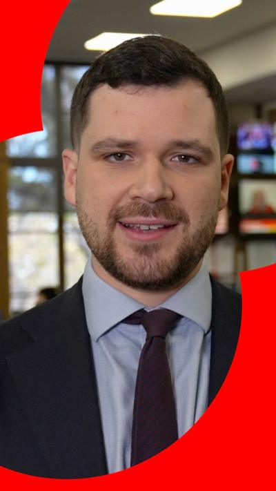 Henry Zeffman wears a suit. He has a beard