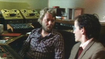 Music producer Martin Rushent and Riverside reporter Mike sit at a recording desk