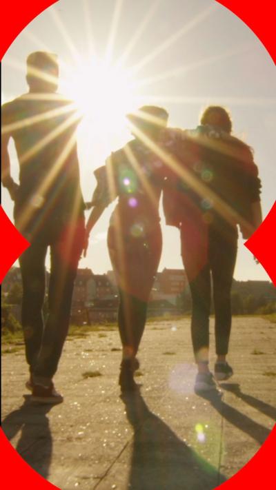 Silhouettes of three people walking in the sunshine 