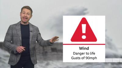 BBC weather presenter next to Wind Danger to Life symbol