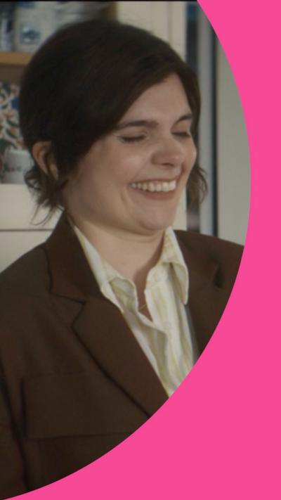 Death Valley character detective sergeant Janie Mallowan laughs. Her hair is tied back and she is wearing a brown jacket