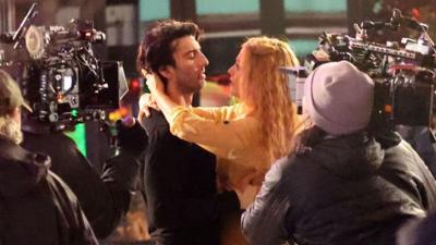 Blake Lively and Justin Baldoni embracing as they film a scene on a street for the film It Ends With Us