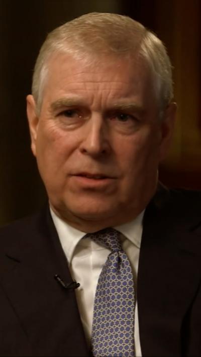 Andrew, who has grey hair, has a serious expression during the interview