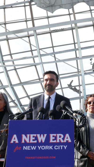 New York City mayor-elect Zohran Mamdani, alongside his mayoral transition team, speaks during a news conference.