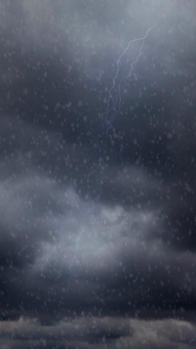 Lightning strikes through dark clouds and falling snow