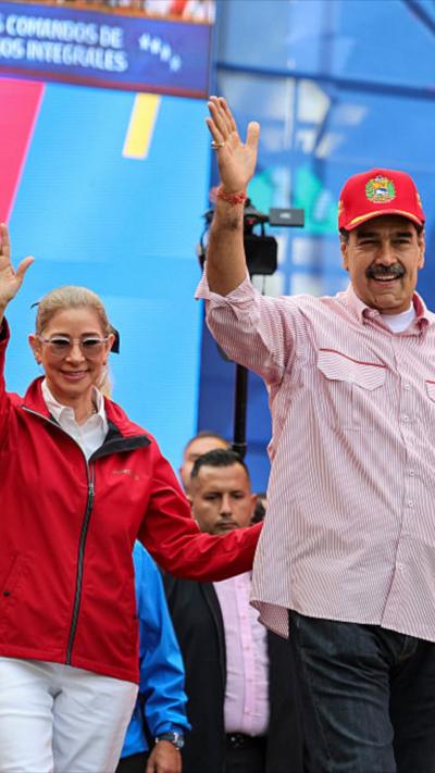 Cilia Flores and husband Maduro waving.