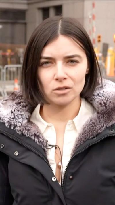 Madeline Halpert speaks into a mic in front of NY court.