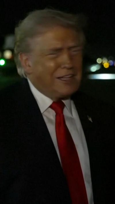 US President Donald Trump wears a red tie, white shirt and black suit.