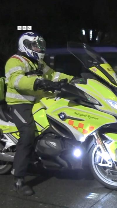 A man in yellow on a motorbike.