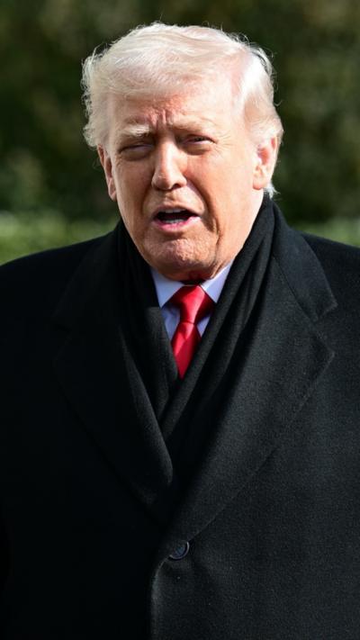 Donald Trump speaks to reporters before departing the White House.