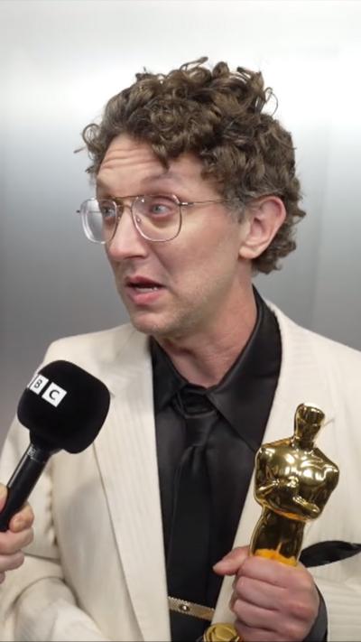 David Borenstein, holding an Oscar statuette, speaks to the BBC's Colin Paterson