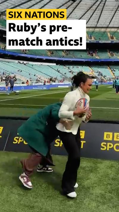 Ruby Tui plays with ball helpers and is rugby tackled by Maggie Alphonso