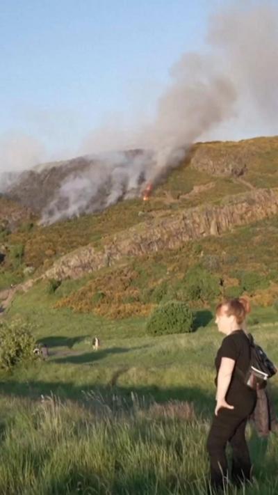 Woman watches as fire burns near Edinburgh's Arthur's Seat