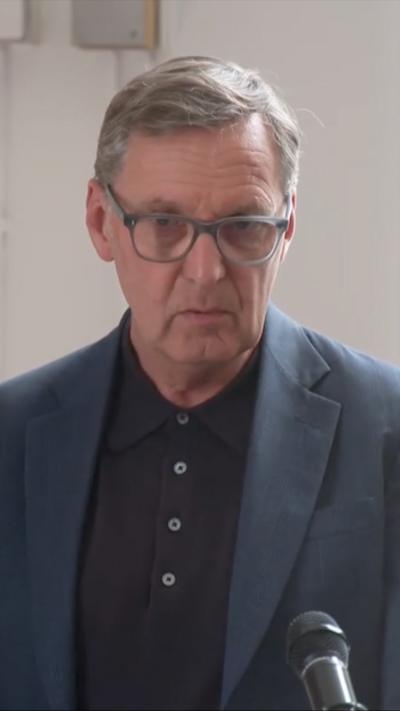 Alan Milburn in a dark suit and glasses