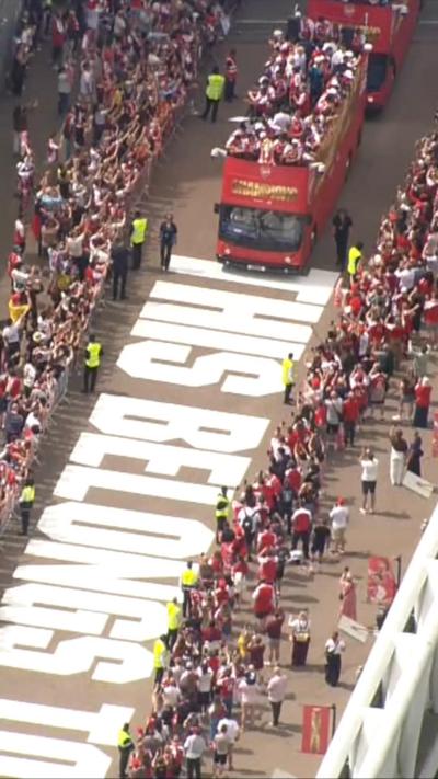 A bus carrying players is seen driving along a bridge