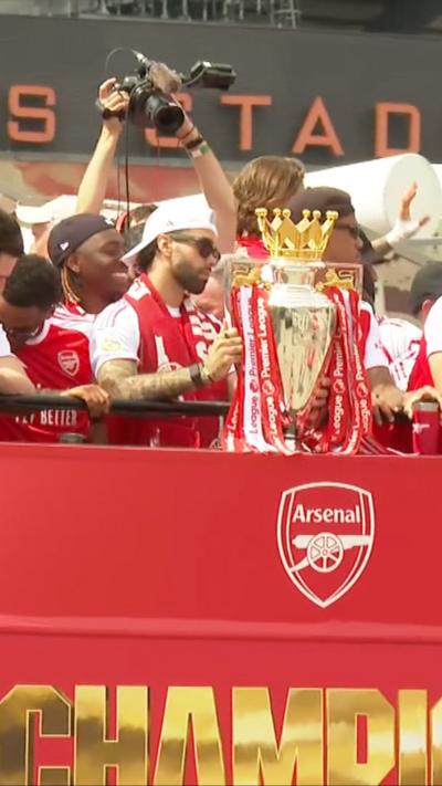 Arsenal seen on top of parade bus with premier league trophy