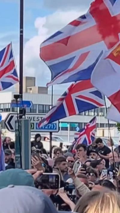 A group of protesters holding up Great Britain flags