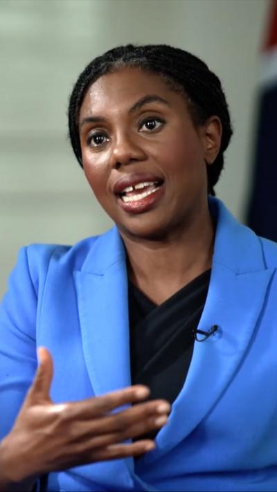 Kemi Badenoch wears a blue blazer and black top as she speaks to the BBC