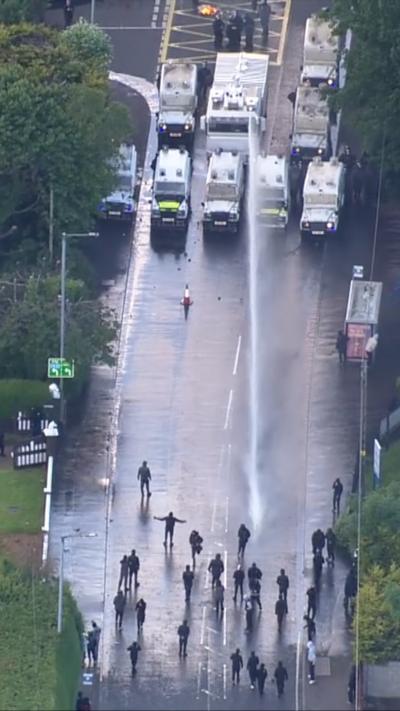 Protesters being sprayed with water canon.