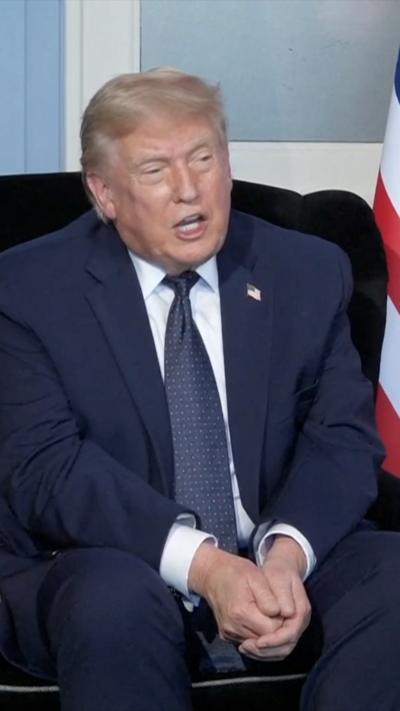A man in a blue suit sitting in a chair.